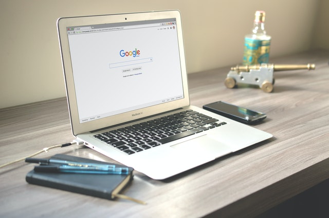 A laptop on a desk with Google opened in a browser.